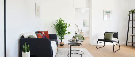 Appartement rénové par marchands de bien à Nantes et mis en ambiance pour la vente grâce au home staging par AntePostea. Salon meublé avec canapé, tapis, table basse, fauteuil , plante, déco...